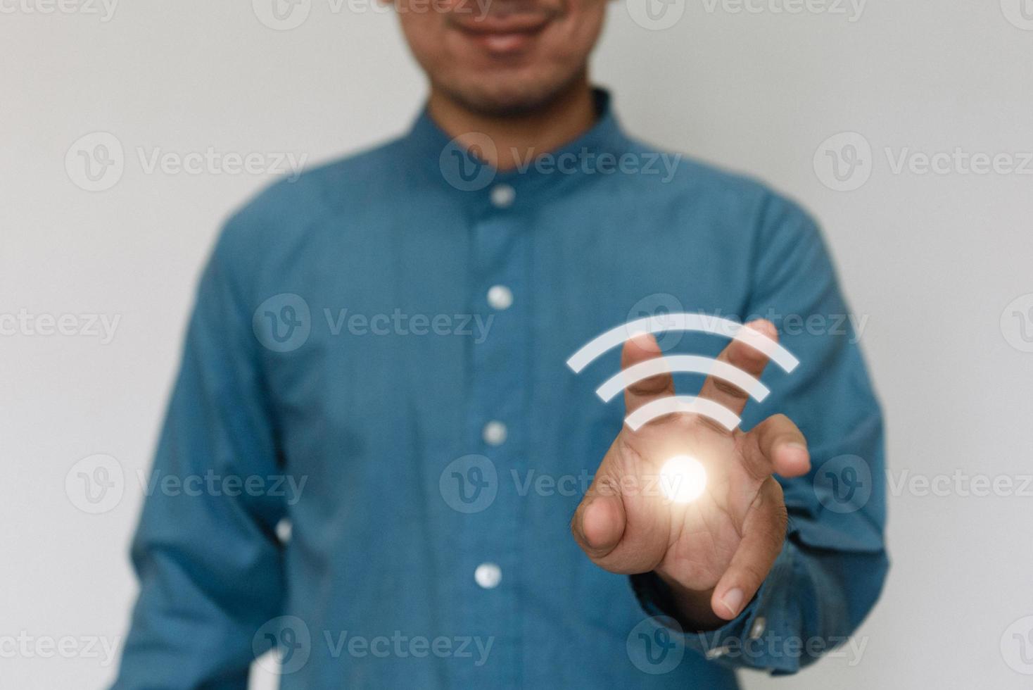 Young handsome wearing a light blue shirt turn on wifi and connected to Wi-Fi technology for using smart home function. Technology business and modern lifestyle concept. photo