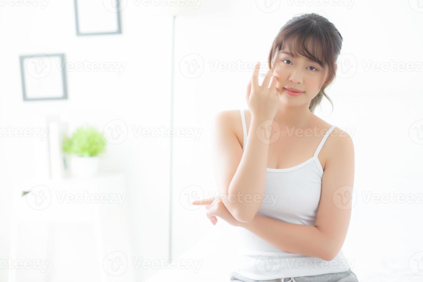 Portrait of beautiful young asian woman smile healthy and wellness at the bedroom, beauty asia girl skin care touch eye makeup and cosmetic with happy with fresh, lifestyle and relax concept. photo