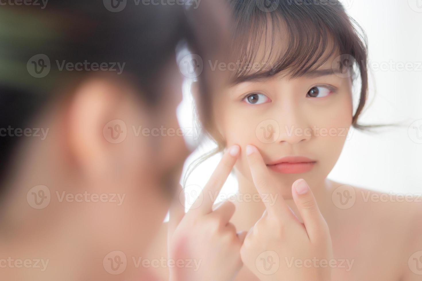 Portrait beautiful young asian woman looking the mirror is a acne, zit treatment, girl problem beauty face, perfect with wellness in the bedroom at home with skin care and  healthcare concept. photo