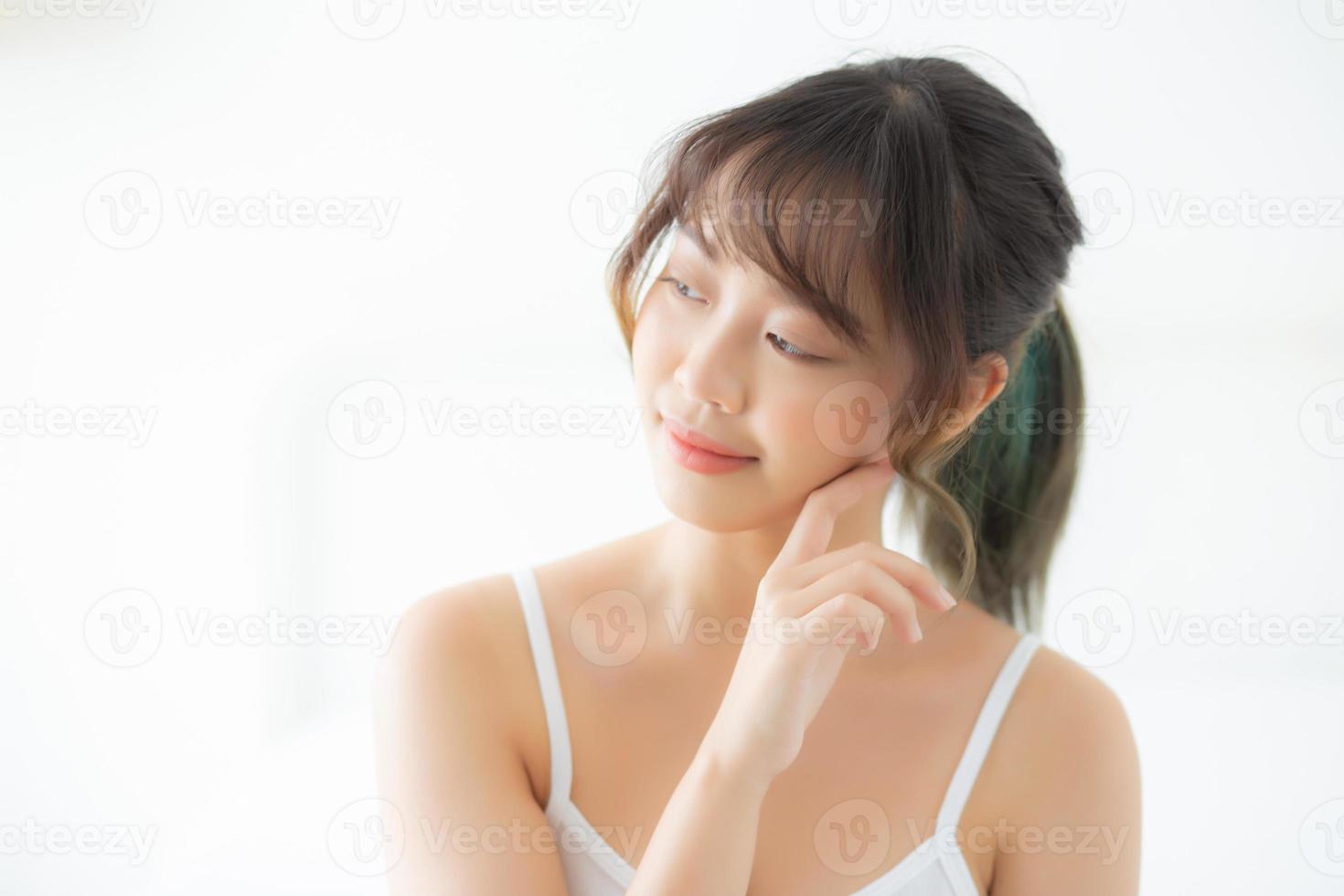 Portrait of beautiful young asian woman smile while wake up healthy and wellness with sunrise at morning in the bedroom, asia girl skin care with happy with fresh, lifestyle and relax concept. photo