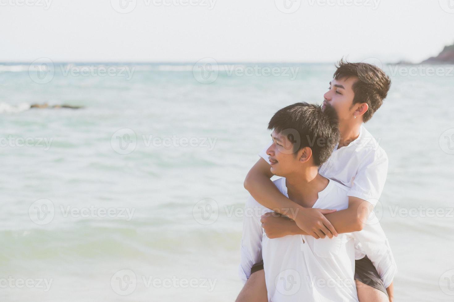 Homosexual portrait young asian couple riding the neck together with enjoy and fun on beach in summer, asia gay cheerful going sea for leisure with romantic and happy vacation at sea, LGBT with legal. photo