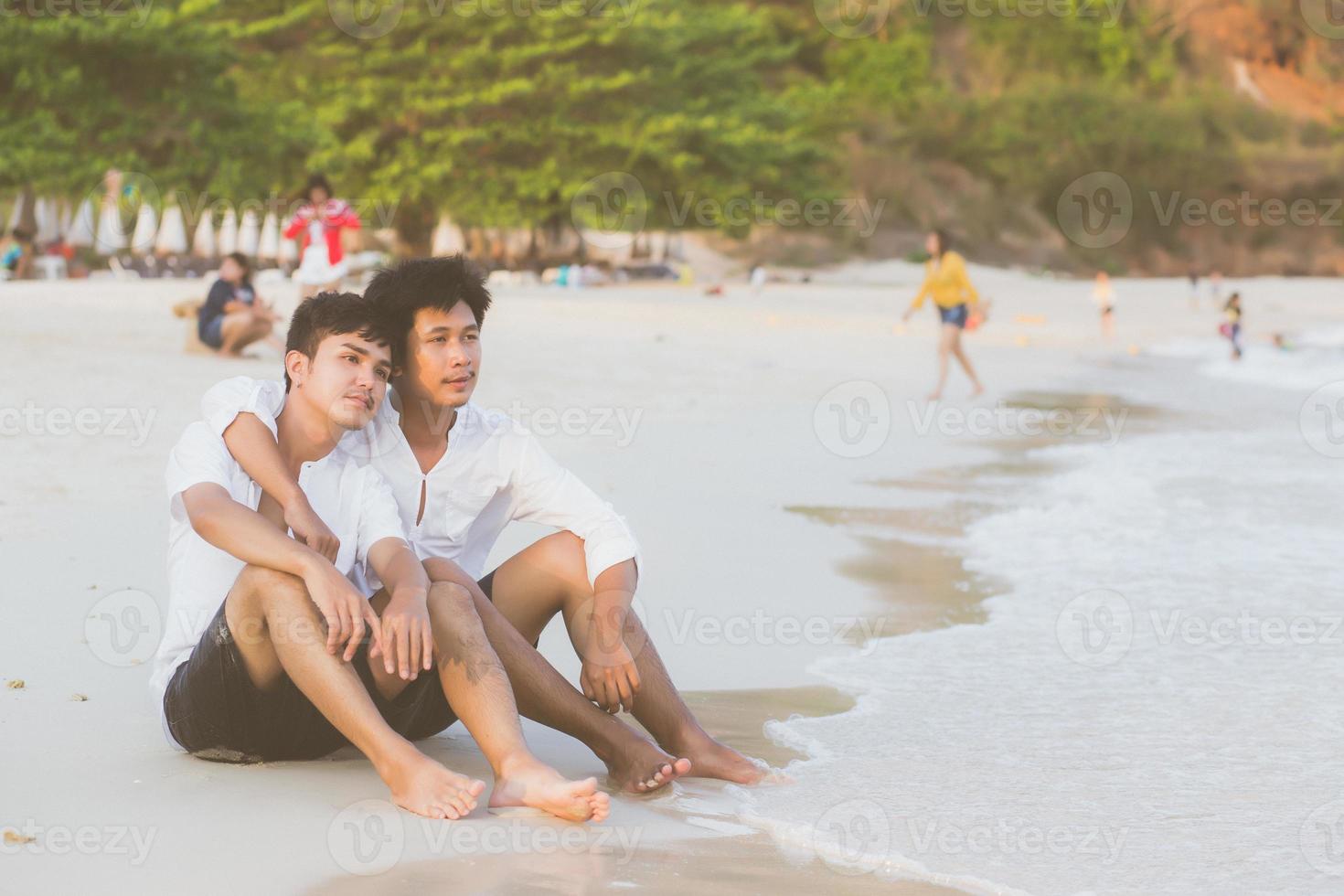 Homosexual portrait young asian couple sitting hug together on beach in summer, asia gay going tourism for leisure and relax with romantic and happiness in vacation at sea, LGBT legal concept. photo