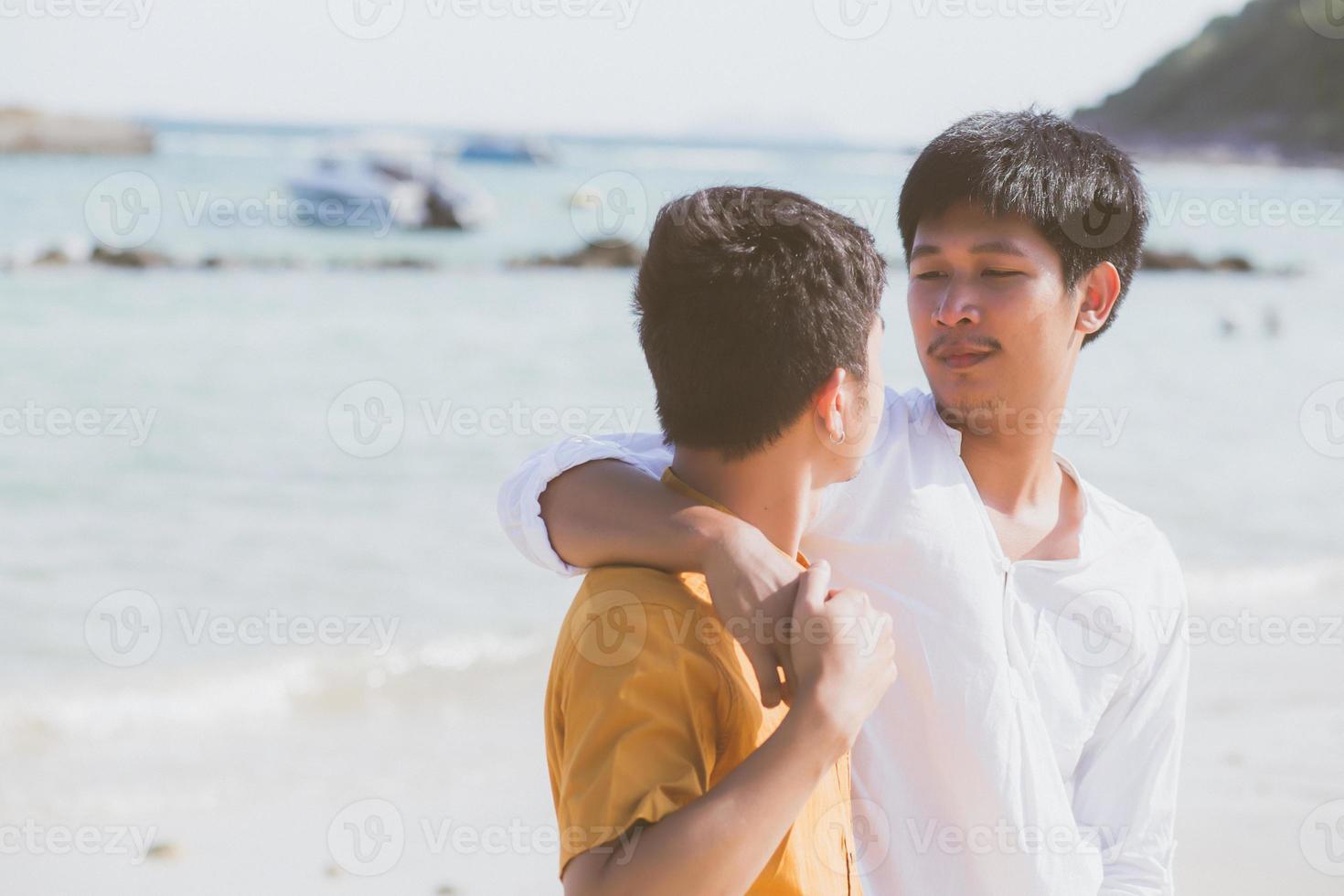 Homosexual portrait young asian couple standing hug together on beach in summer, asia gay going tourism for leisure and relax with romantic and happiness in vacation at sea, LGBT concept. photo