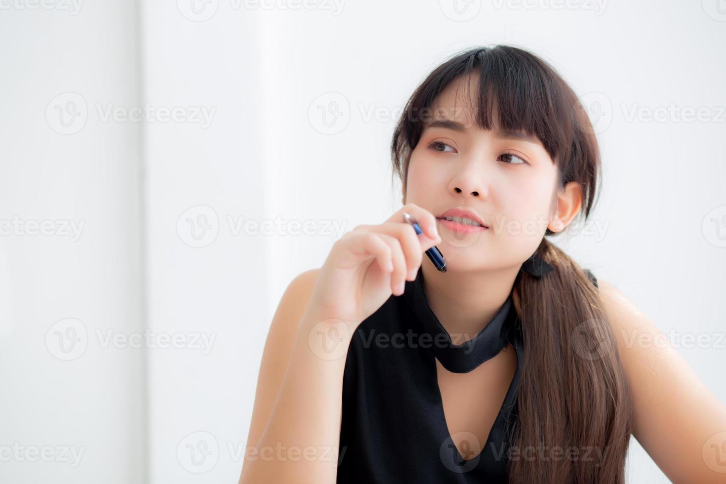 Young asian woman writer smiling thinking idea and writing on notebook or diary with happy on desk office, lifestyle of asia girl is success, female planning working, education and business concept. photo