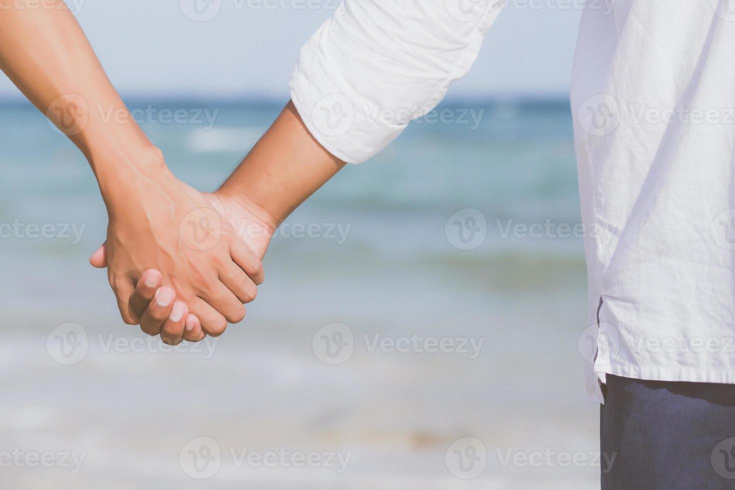 primer plano pareja gay asiática cogidos de la mano juntos en la playa con  relax y