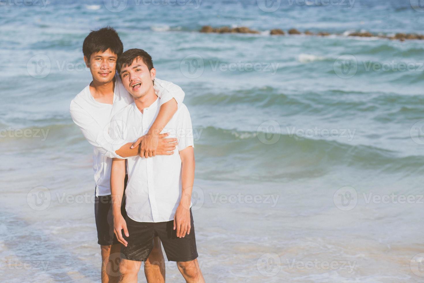 Homosexual portrait young asian couple standing hug together on beach in summer, asia gay going tourism for leisure and relax with romantic and happiness in vacation at sea, LGBT concept. photo