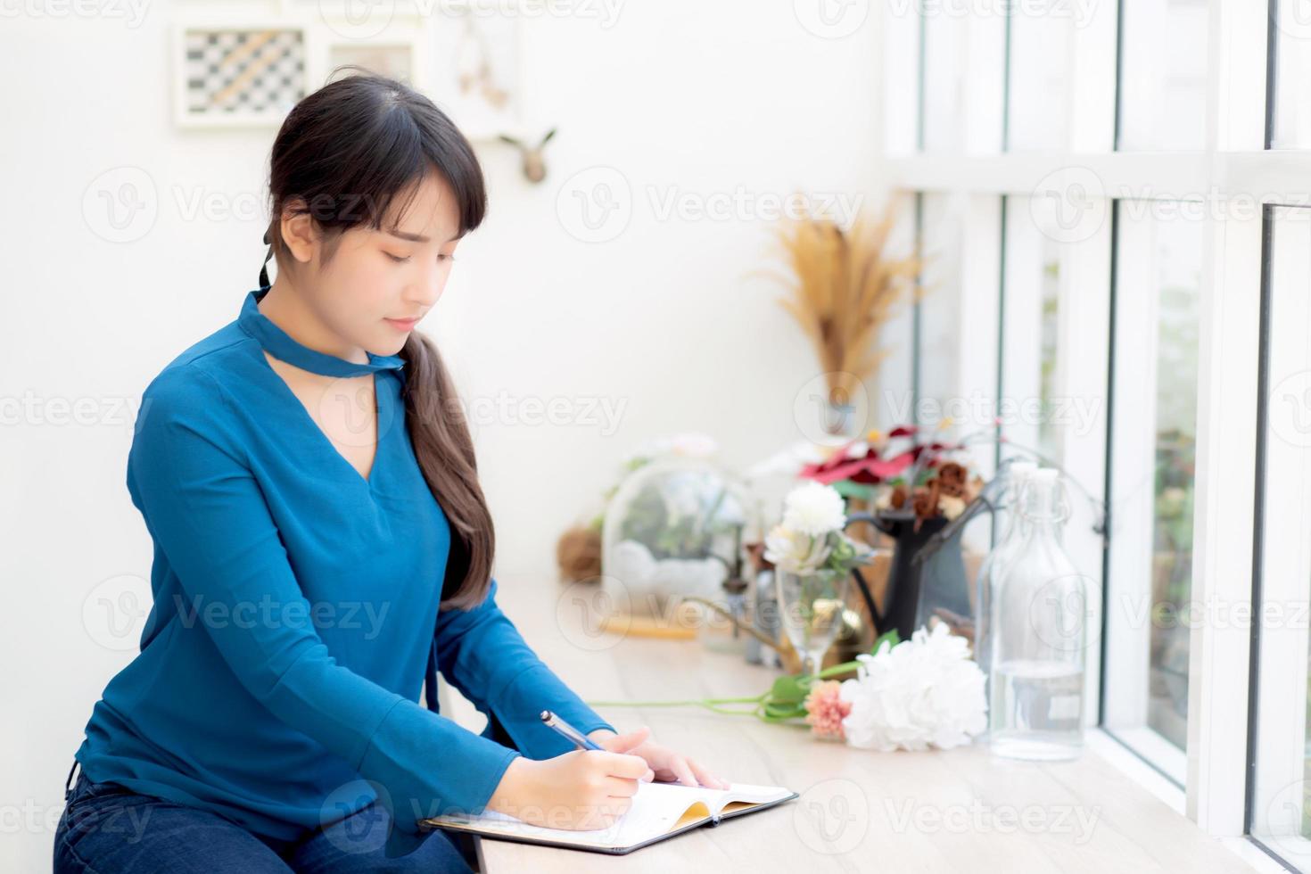 Beautiful portrait young asia woman writer writing on notebook or diary with happy, lifestyle of asian girl is student, female planning working, education and business concept. photo