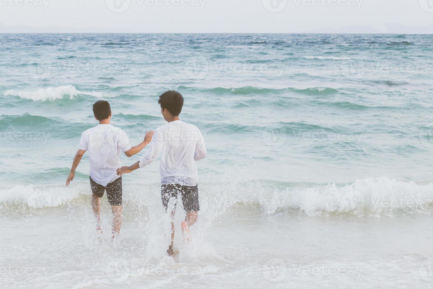 Homosexual portrait young asian couple running with cheerful together on beach in summer, asia gay going tourism for leisure and relax with happiness in vacation at sea, LGBT legal concept. photo