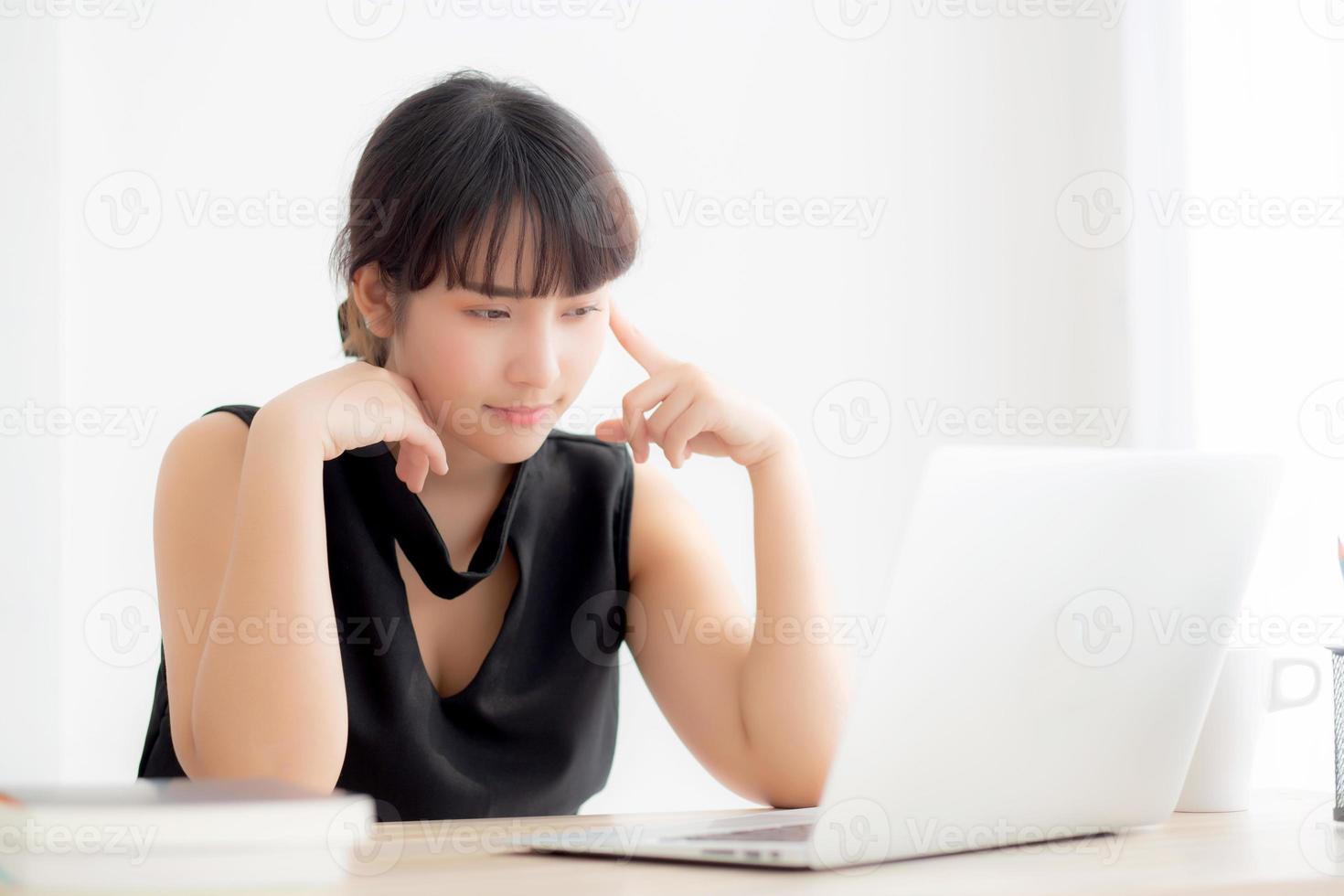 Beautiful freelance young asian woman thinking and idea working laptop computer at office, writer asia girl thoughtful inspiration writing blogging with notebook in job, business concept. photo