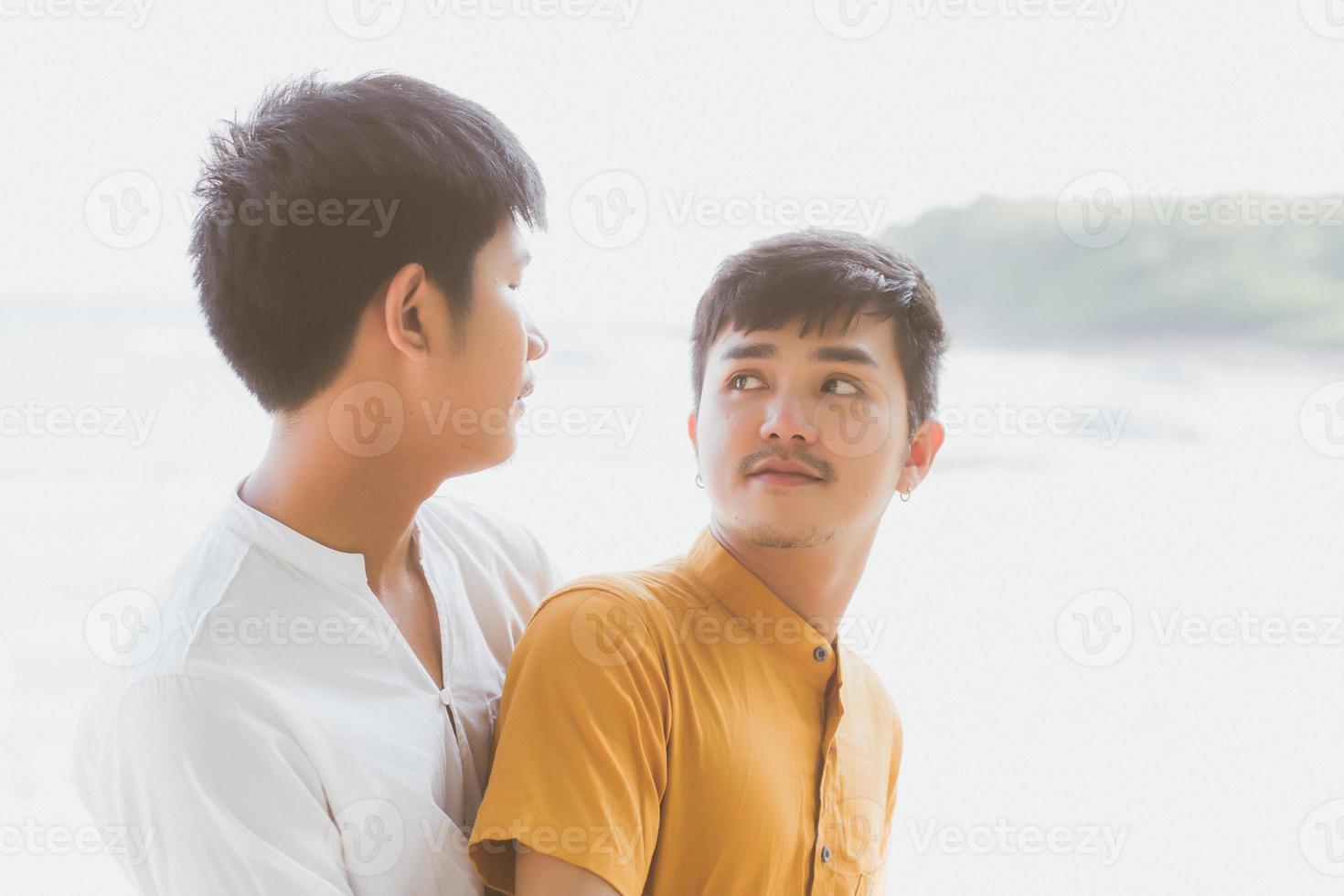 Homosexual portrait young asian couple standing hug together on beach in summer, asia gay going tourism for leisure and relax with romantic and happiness in vacation at sea, LGBT concept. photo