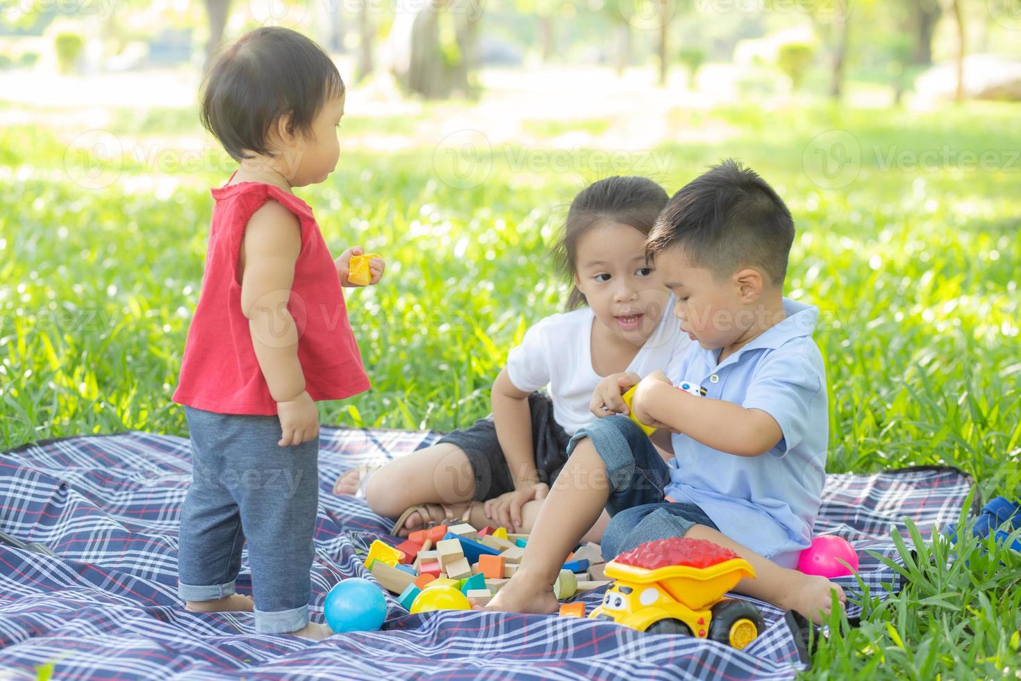 Little boy and girl is playing for idea and inspiration with toy block, kid learning with construction block for education, child activity and game in the park with happy in the summer. photo