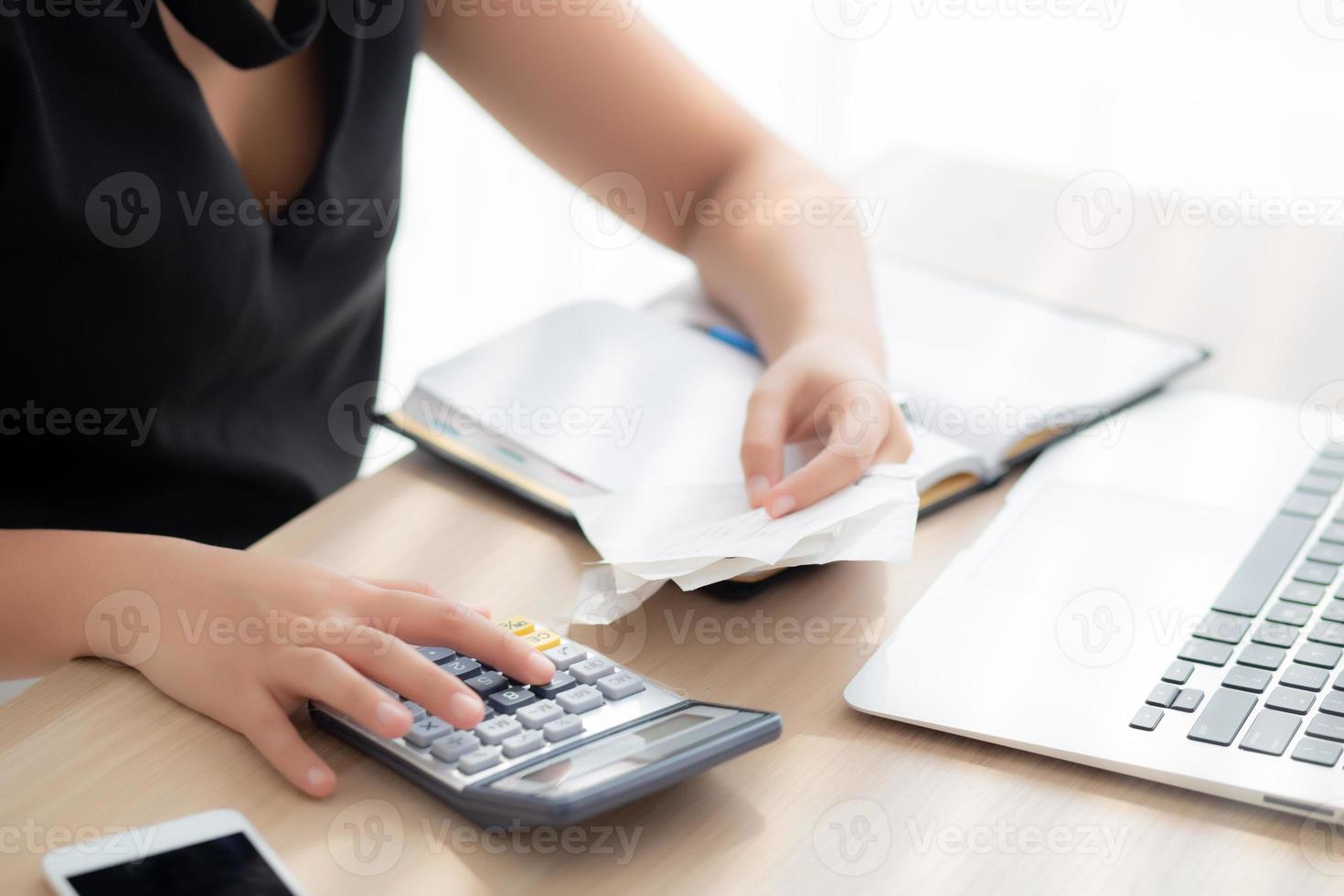 closeup hand woman calculating expenses household and writing notebook on desk, girl checking bill and stress and note, female worry debt and tax, finance and business concept. photo