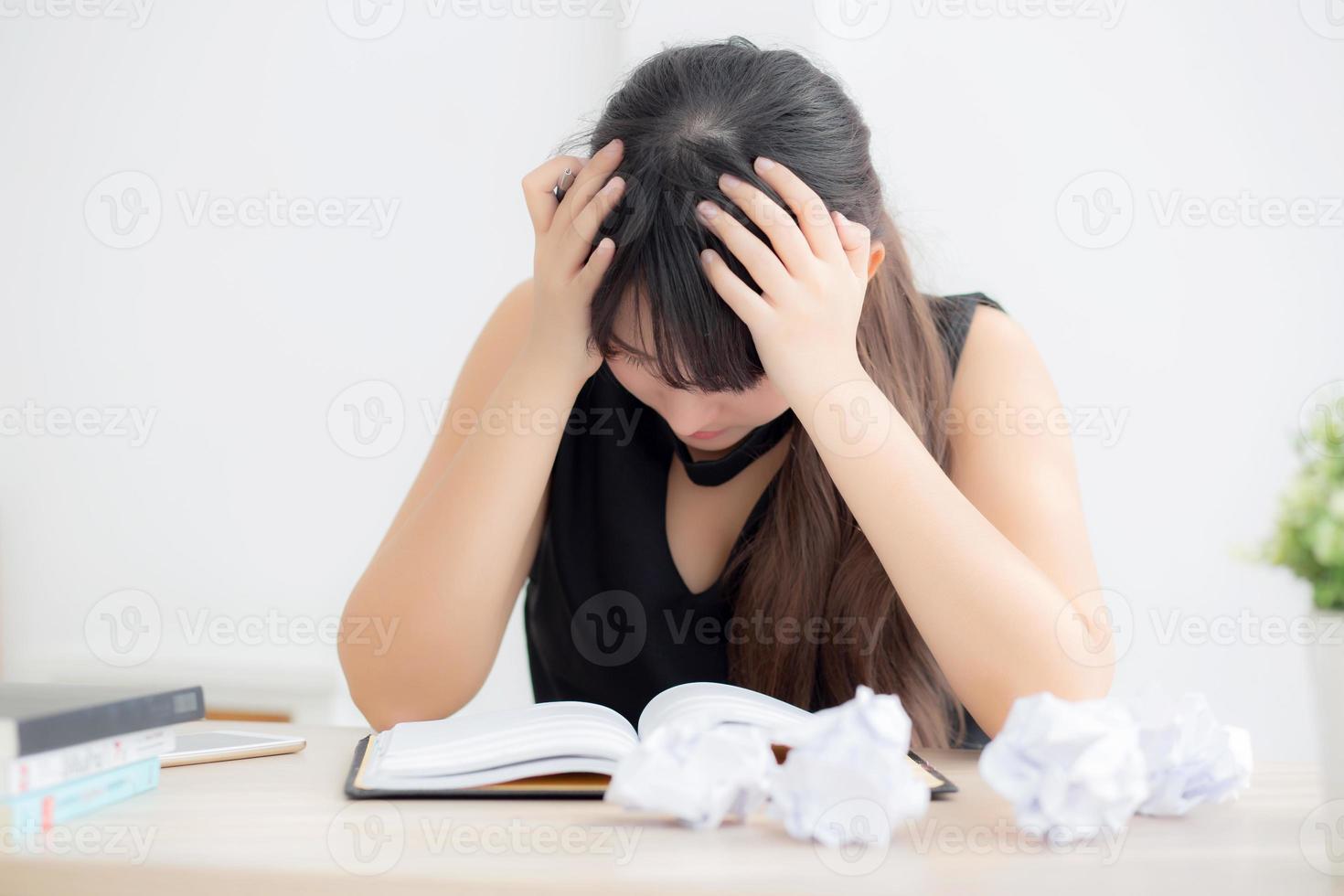 Beautiful asian woman tired and stressed with writing overworked at desk, girl with worried not idea with notebook and crumpled paper at office, freelance and business concept. photo