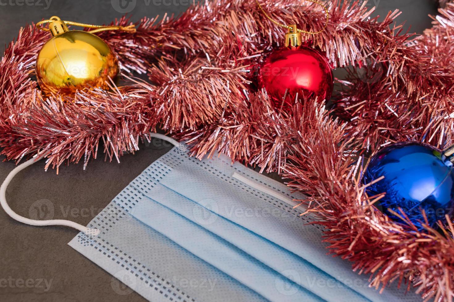 Protective medical mask symbolizing the problem of coronavirus next year and Christmas decorations as a symbol of hope for the best photo