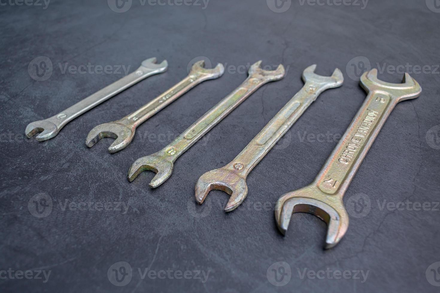 Set of new wrenches made of chromium and vanadium alloy on a dark surface photo