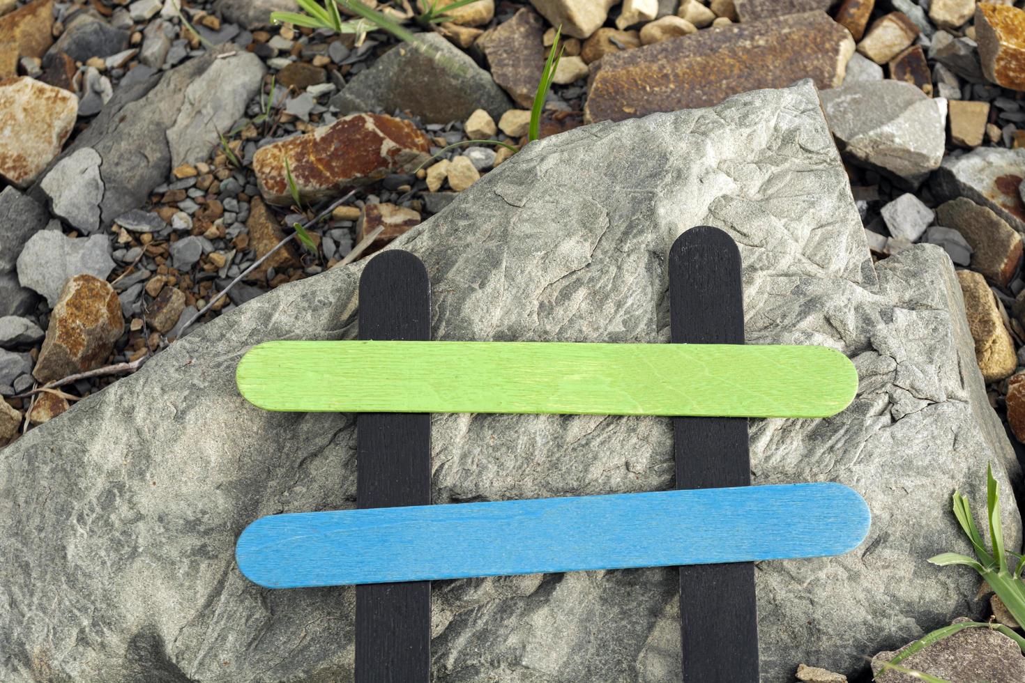 Colorful wooden stick on stone beach background. Copy space. Directly above. photo