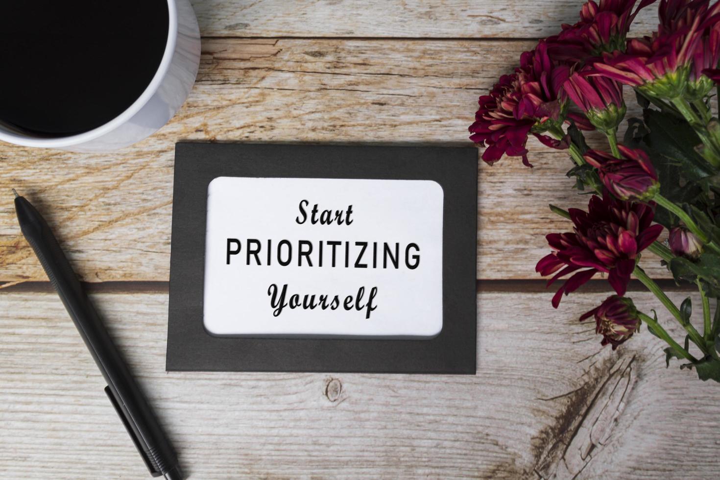 Motivational quote on chalkboard frame and white flowers on on wooden desk. photo