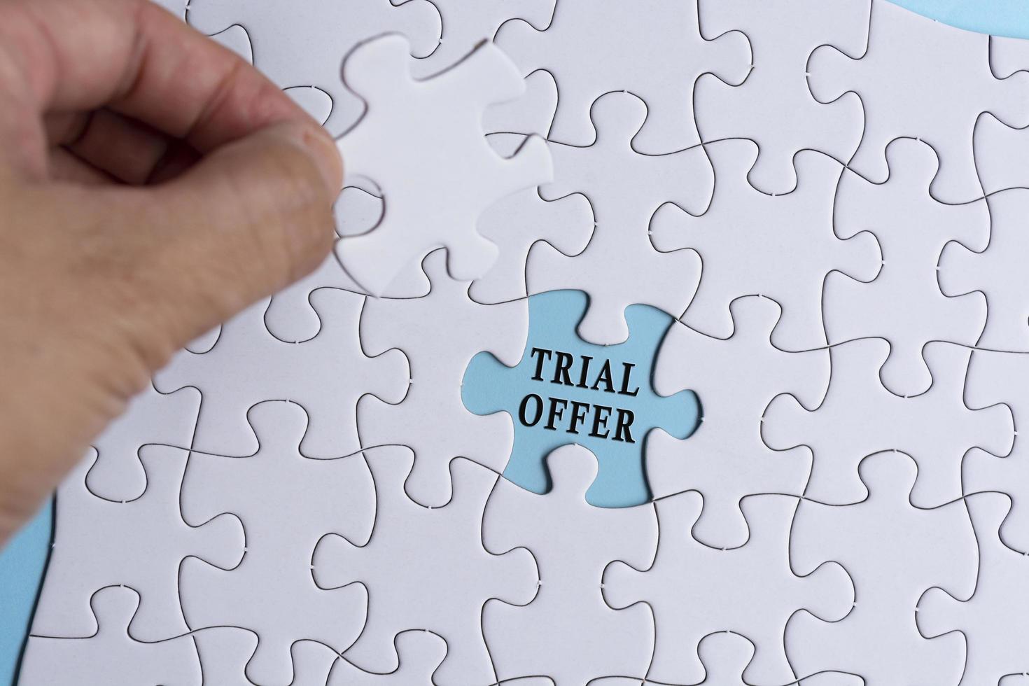 Person's Hand Holding Piece Of Puzzle With Text Trial Offer. photo