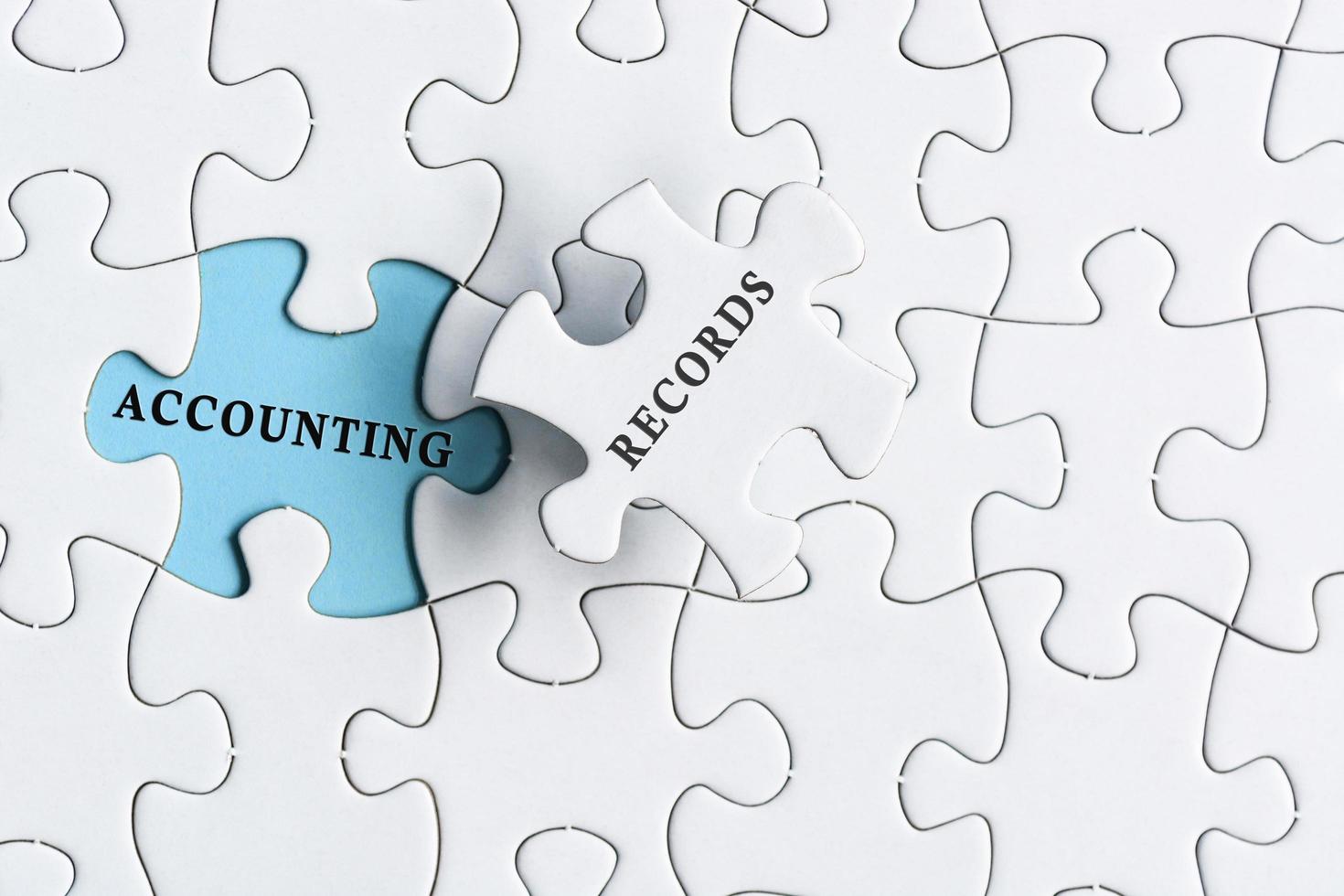 Accounting records text on blue background of white jigsaw puzzle. photo