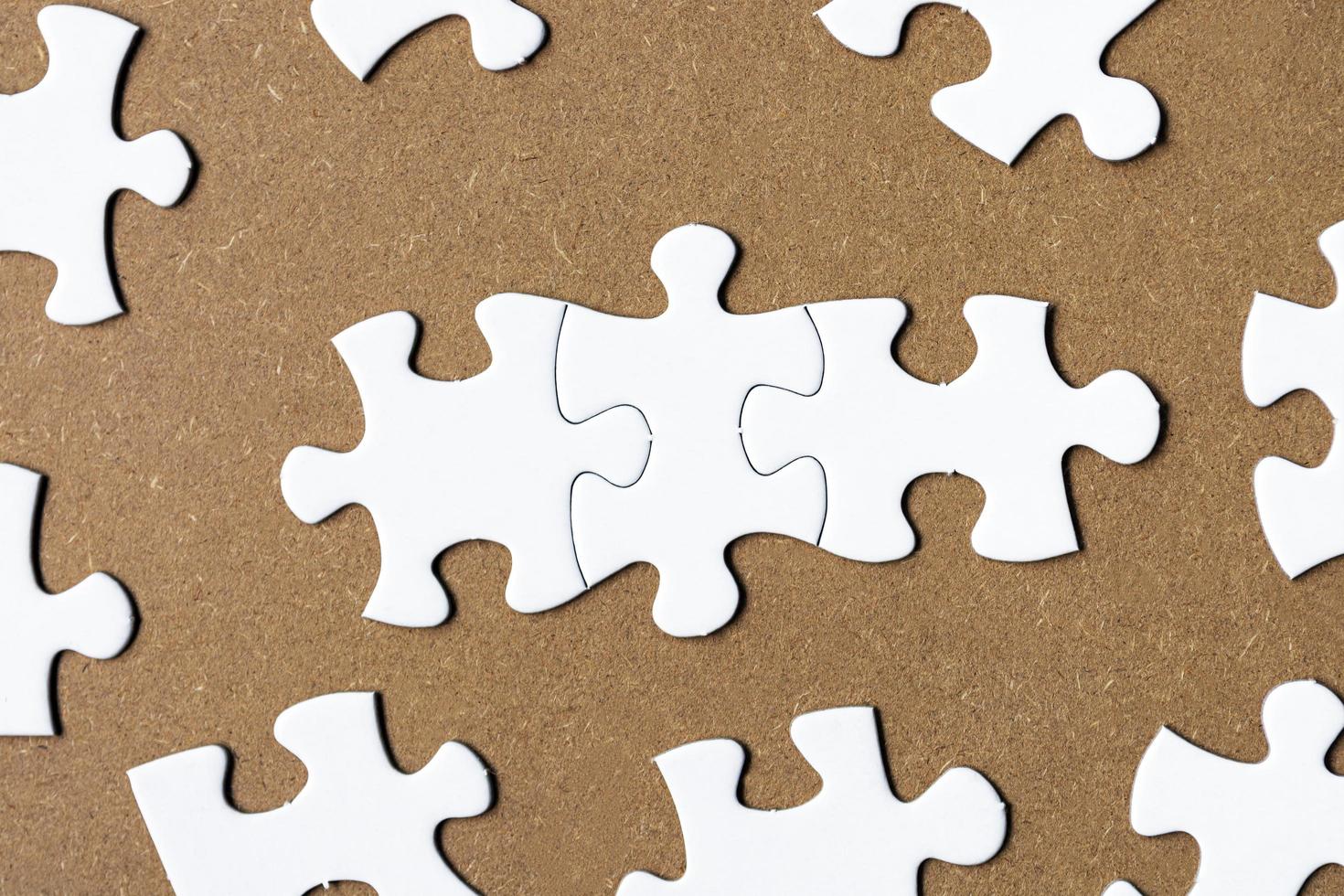 White jigsaw puzzle on wooden background. Directly above. Flat lay. photo