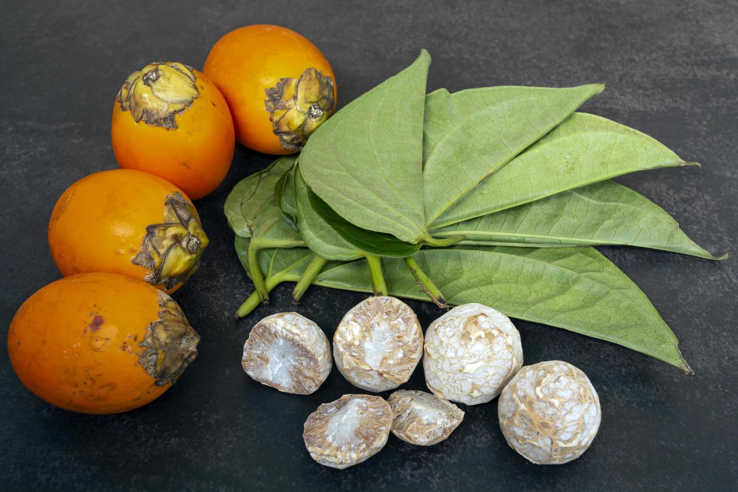 Betel nut or areca nut with betel leaf isolated on dark background. photo