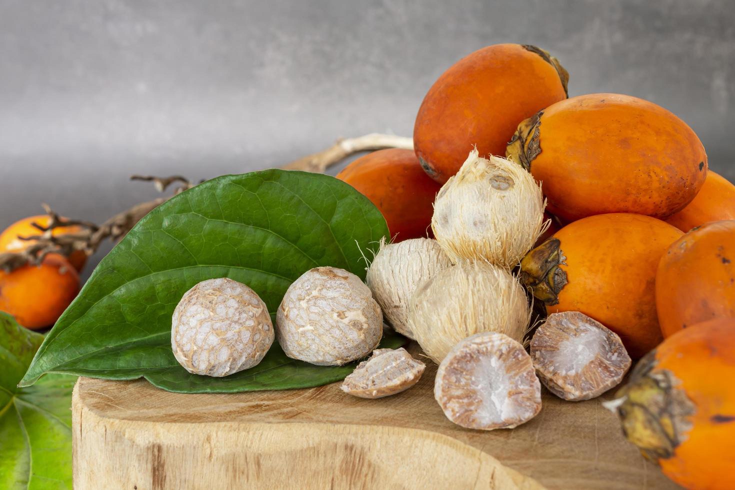 Betel nut or areca nut with betel leaf isolated on wooden background. photo