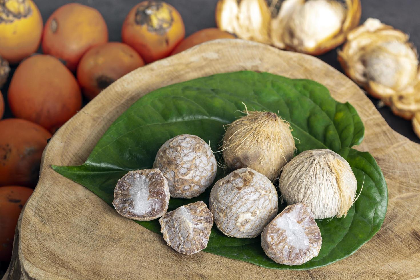 Betel nut or areca nut with betel leaf isolated on wooden background. photo