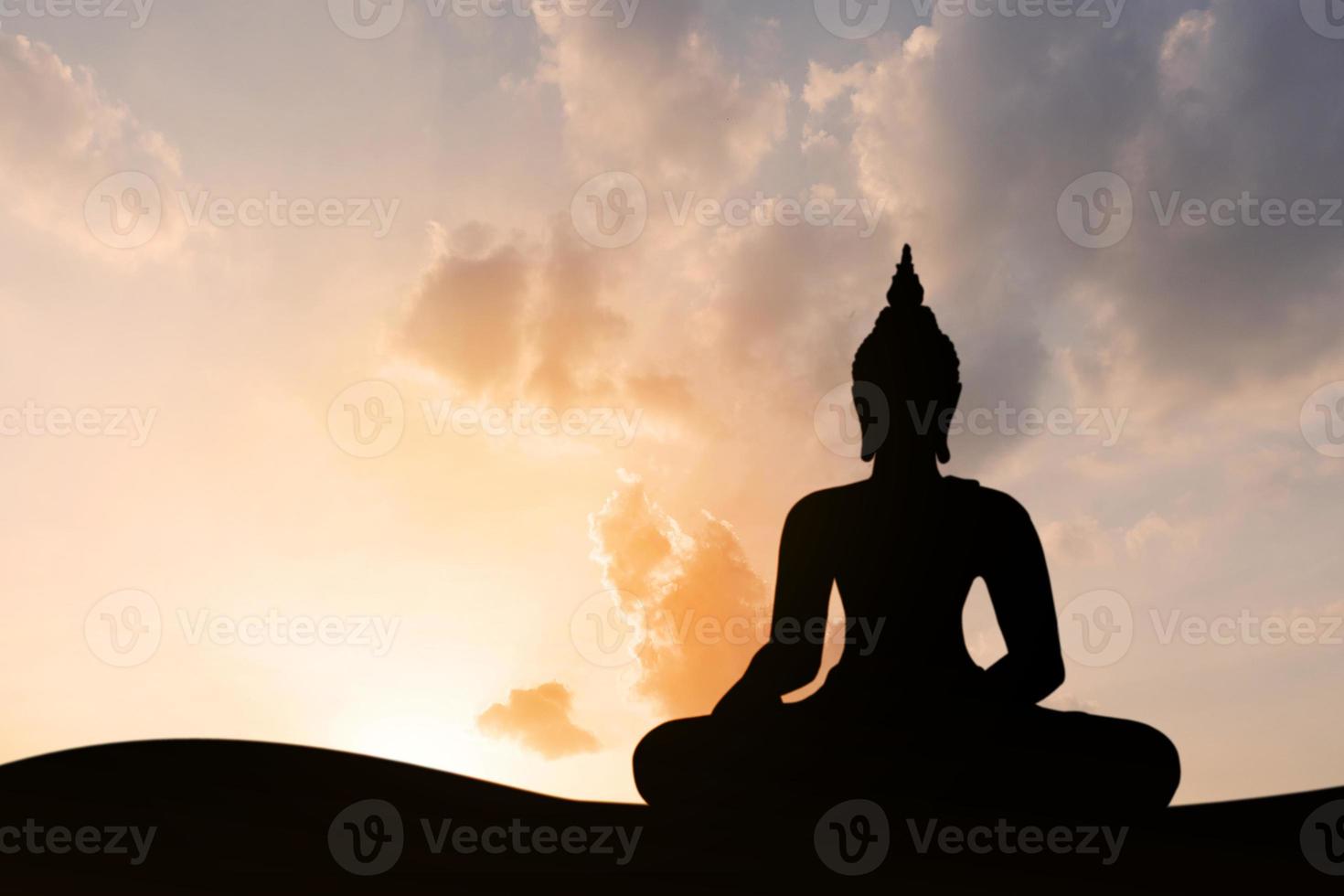 silhouette of buddha at sunset photo