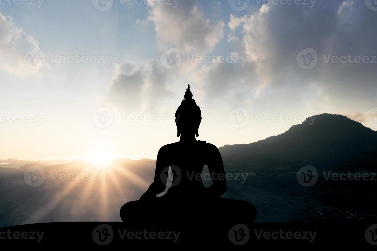 silhouette of buddha at sunset photo