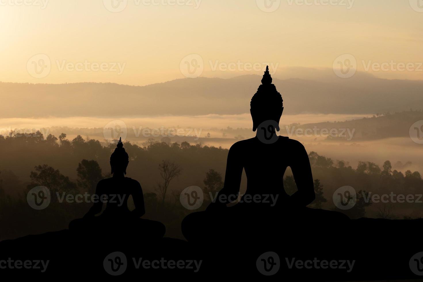 Silhouette Buddha on golden sunset background. photo