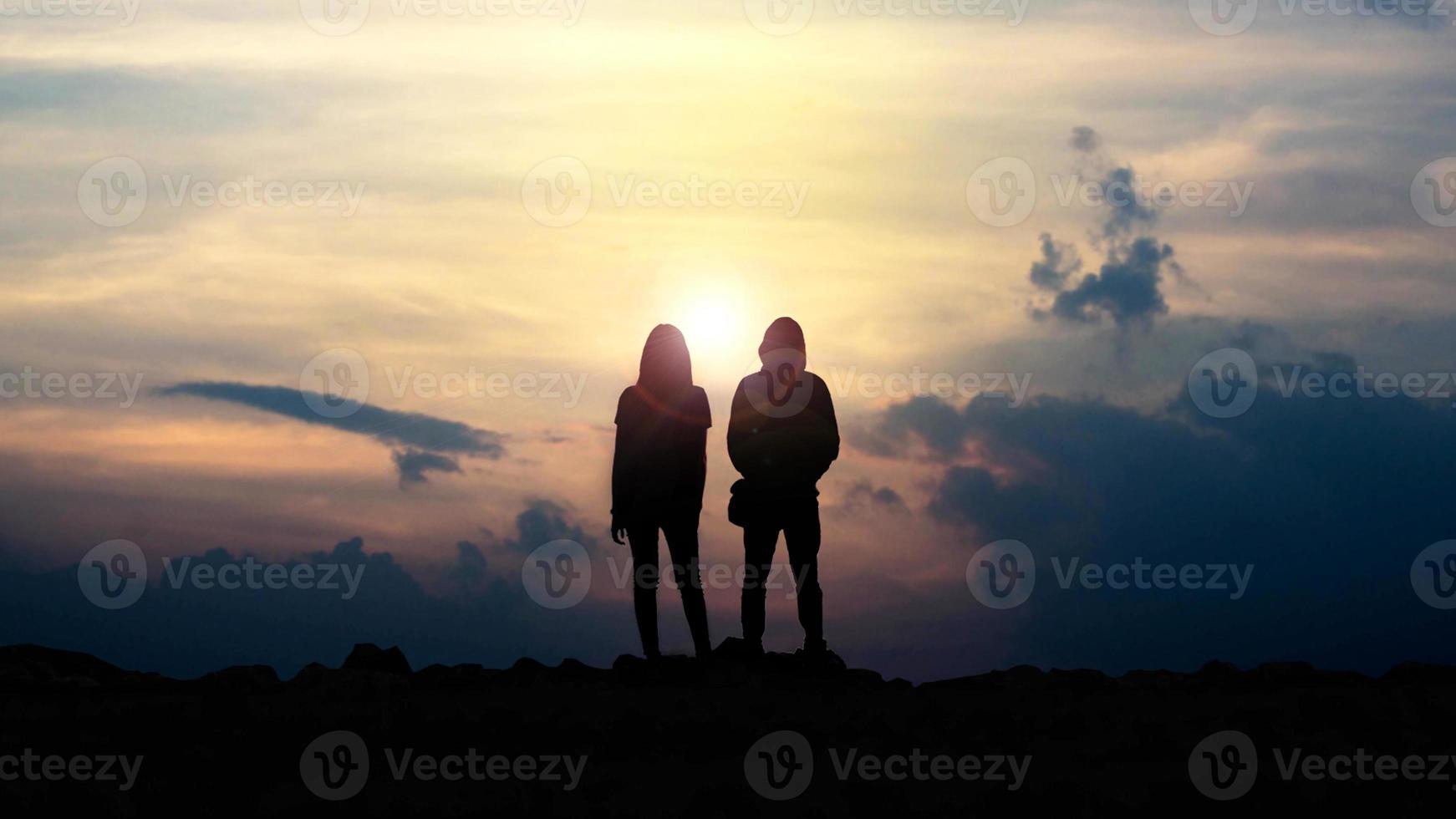 silueta de amor chico y chica contra la puesta de sol foto