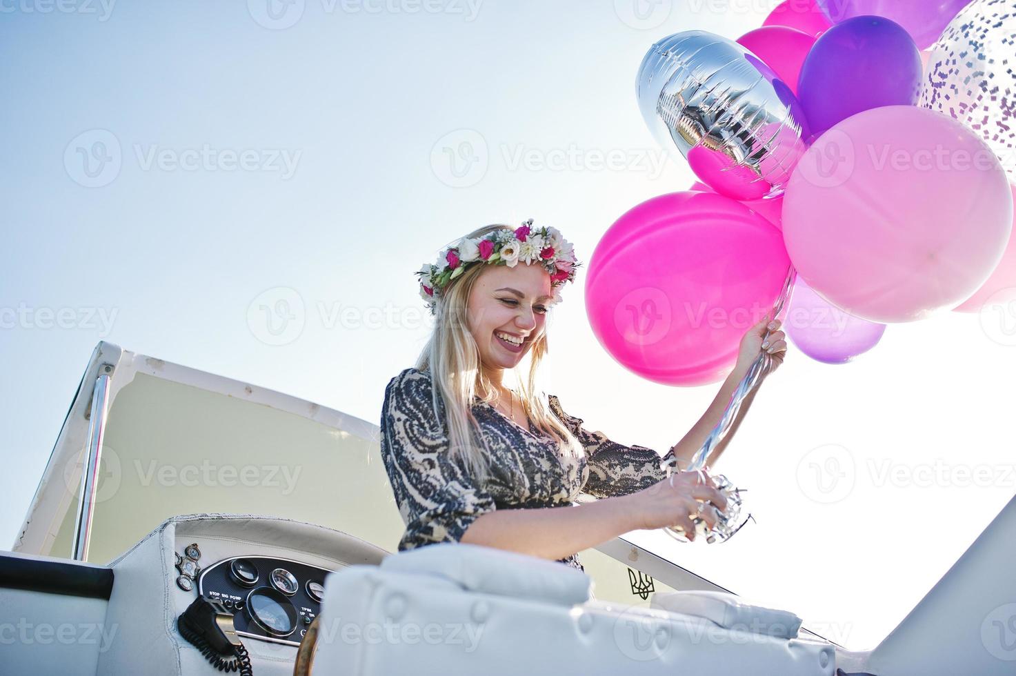 Blonde girl in wreath sitting on yacht at hen party. photo