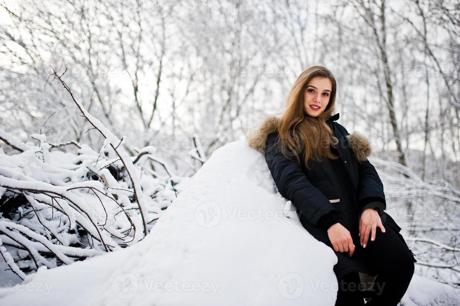 Beautiful brunette girl in winter warm clothing. Model on winter jacket. photo