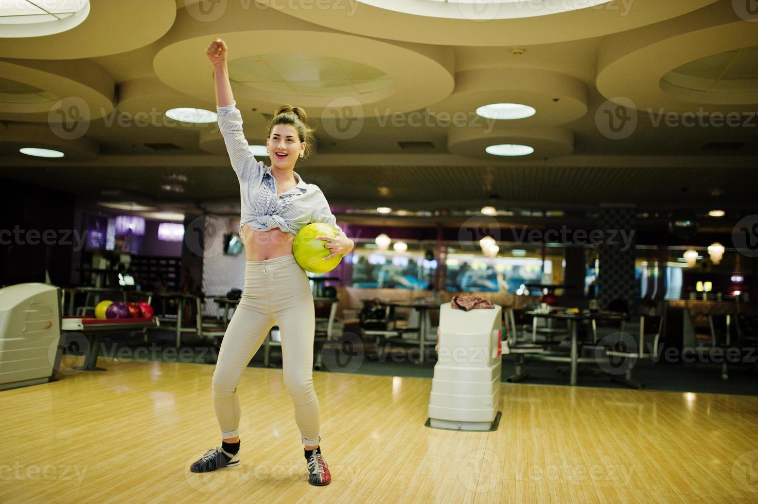 chica con bola de bolos en el callejón jugado en el club de bolos. foto