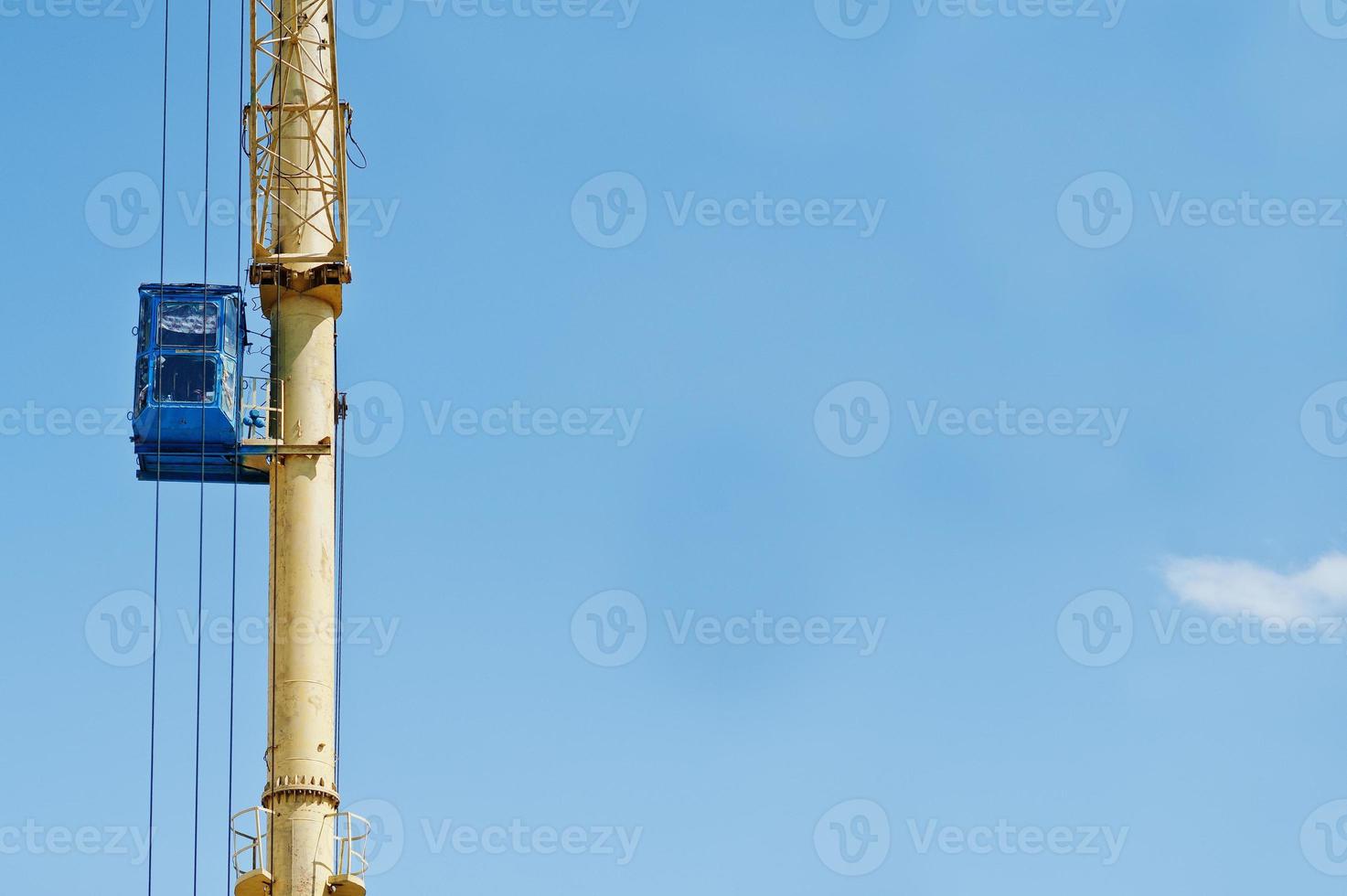 Blue cabin on huge yelllow lifting crane. photo