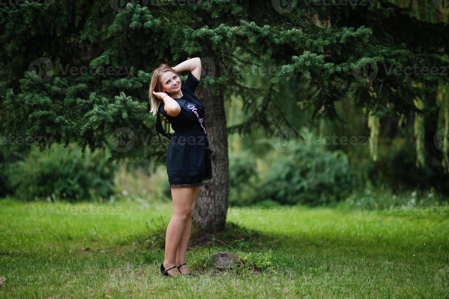 Portrait of gorgeous girl wear on black at hen party, posed at park. photo