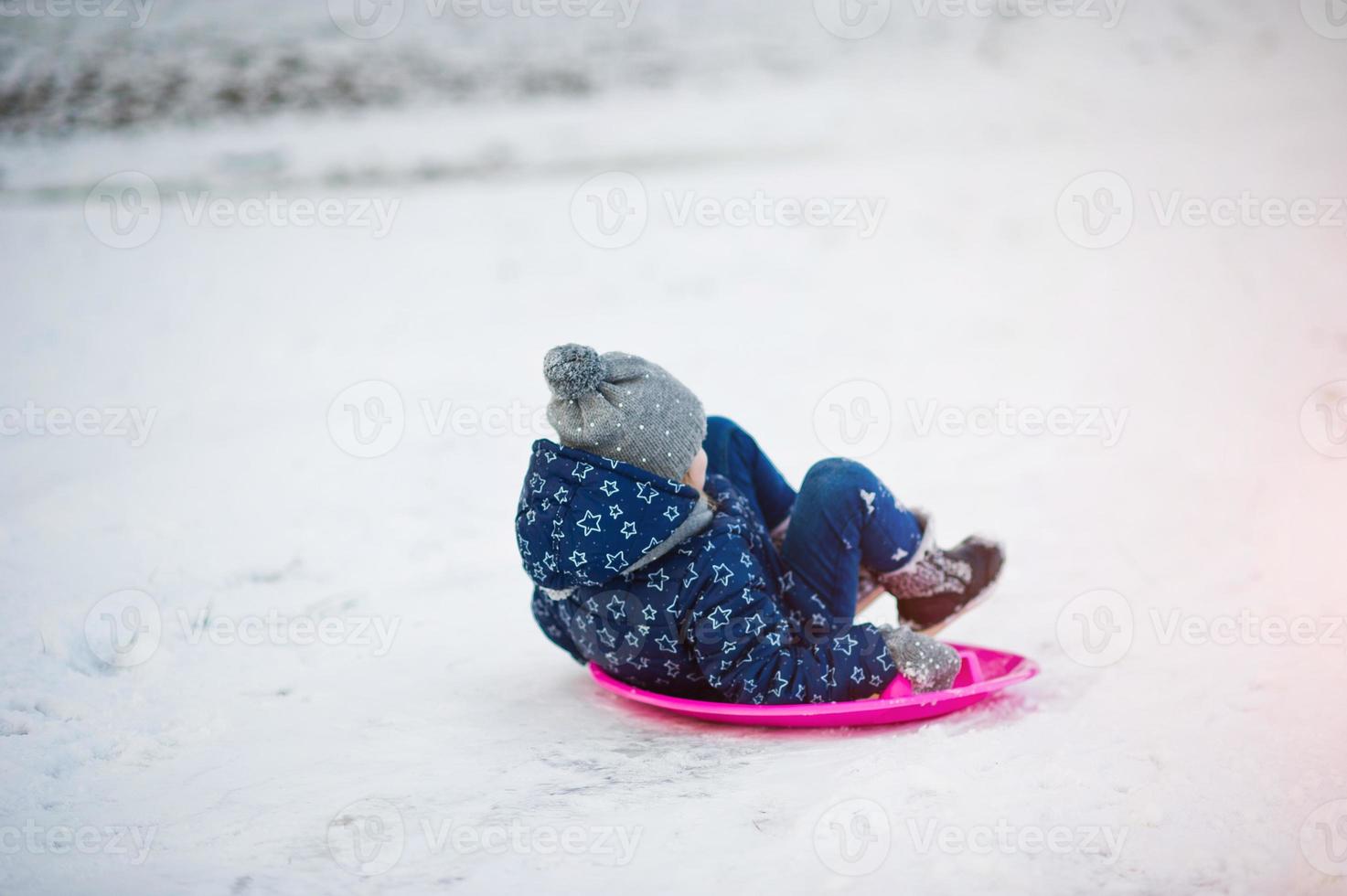 Cute little girl with saucer sleds outdoors on winter day. photo