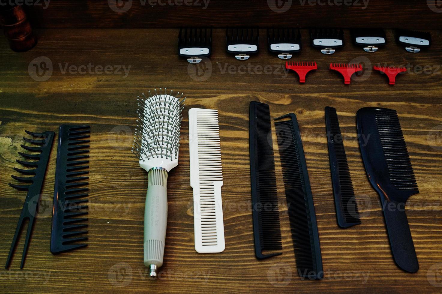 Huge range of various combs and hairbrushes on the wooden surface in barbershop. photo