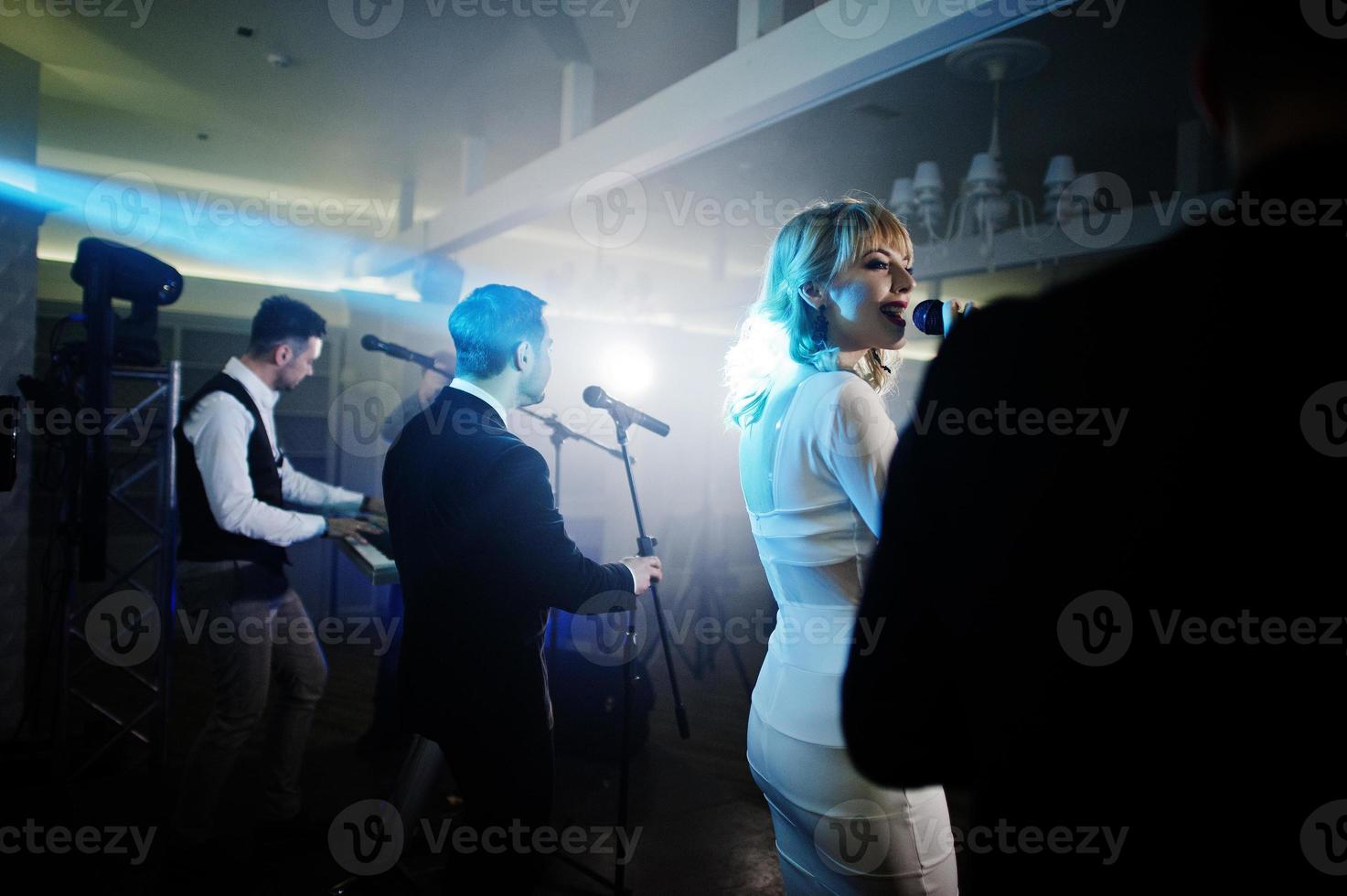 banda de música musical en vivo actuando en un escenario con diferentes luces. foto