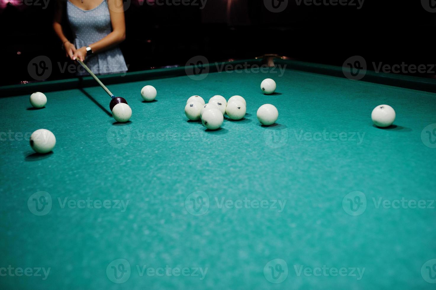 mujer vestida jugando al billar con un hombre en un pub. foto