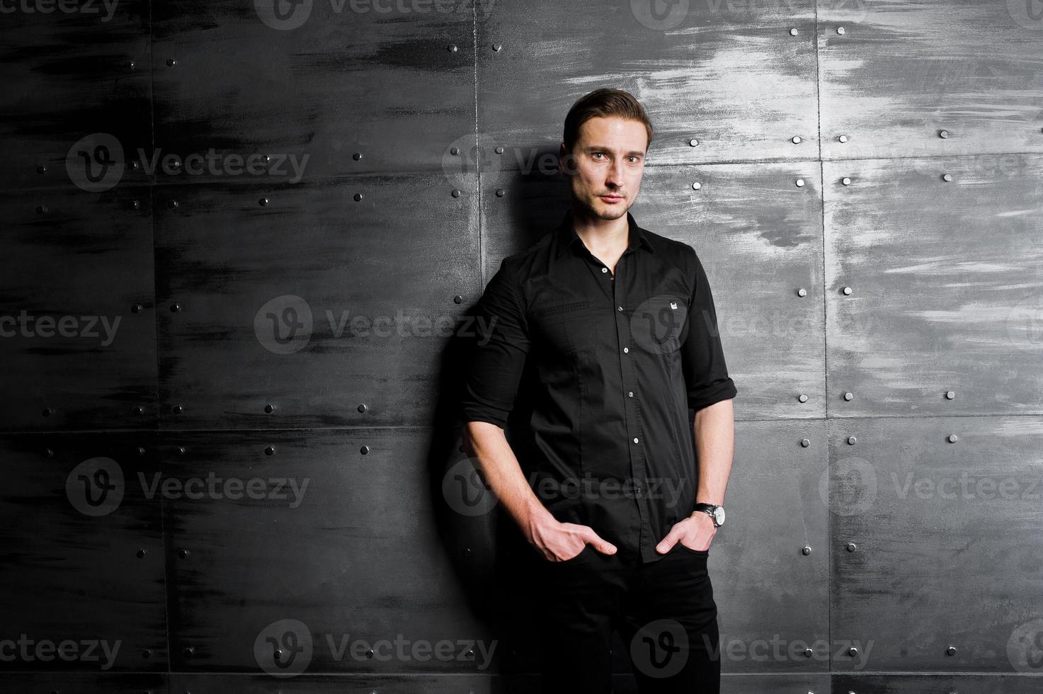 Studio portrait of stylish man wear on black shirt against steel wall. photo