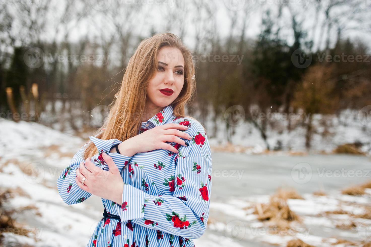 Stylish girl in dress at winter day against frozen lake. photo