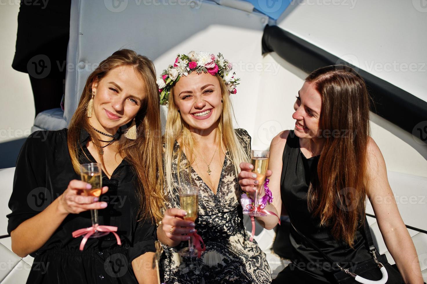Girls drinking champagne at yacht on hen party. photo