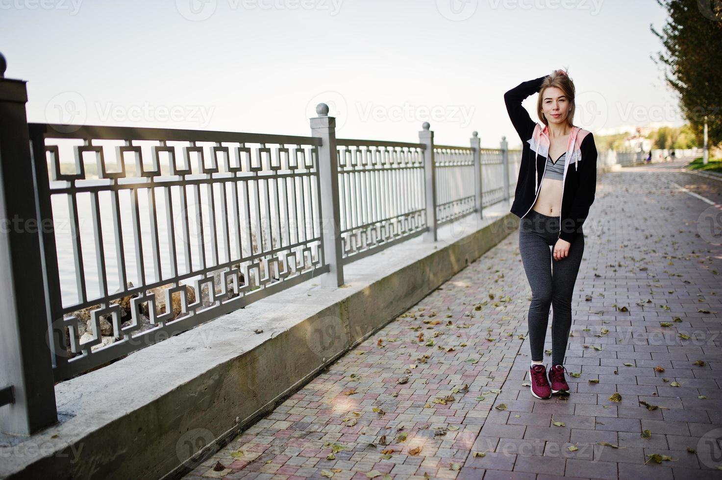 la joven tiene el entrenamiento y hace ejercicio al aire libre. deporte, fitness, concepto de entrenamiento callejero. foto