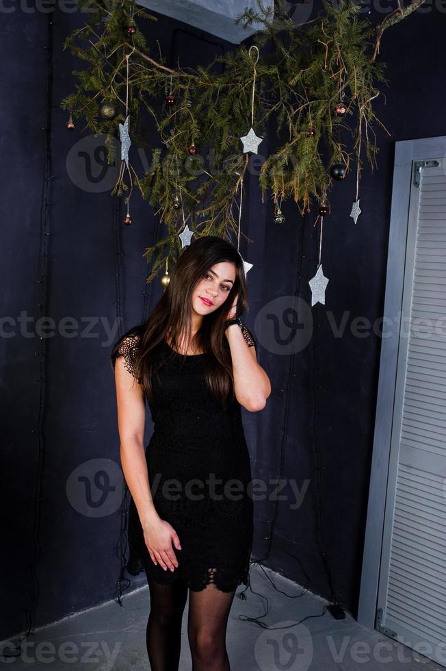 Cute girl wear on black dress against christmas decoration. photo