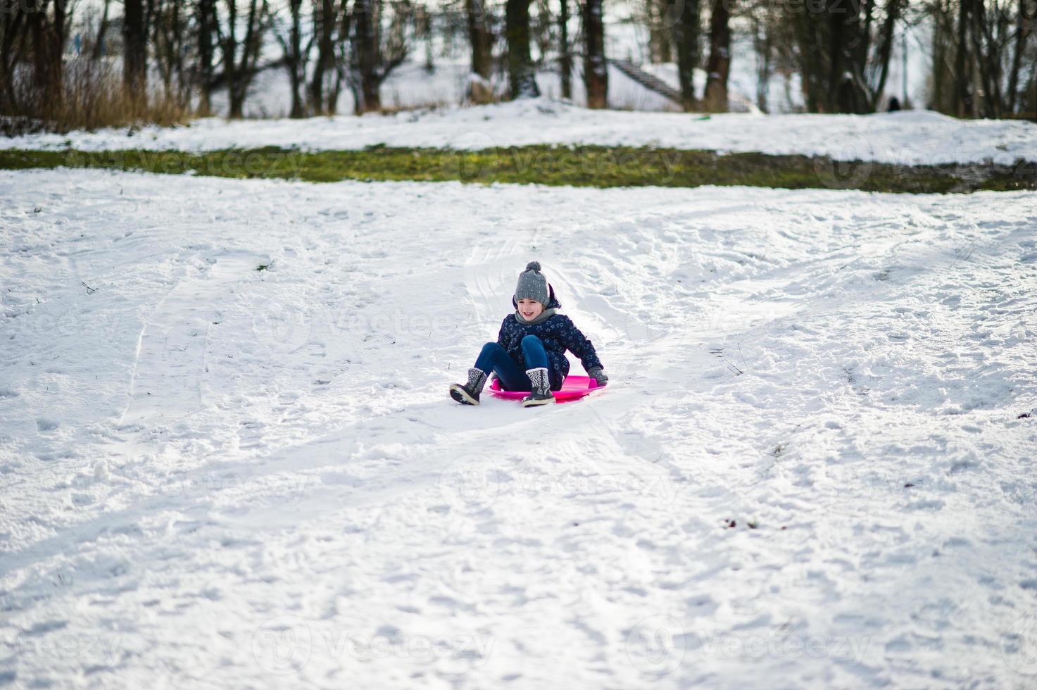 Cute little girl with saucer sleds outdoors on winter day. photo