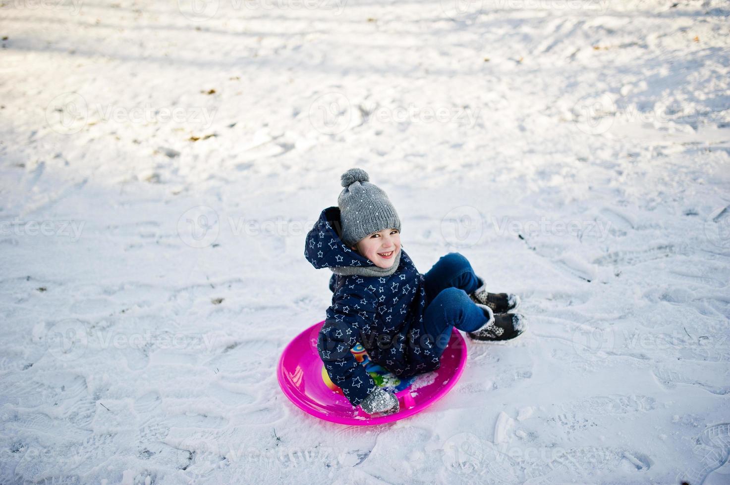 Cute little girl with saucer sleds outdoors on winter day. photo