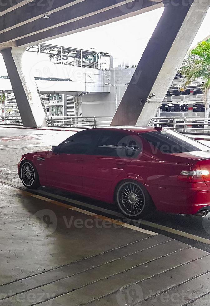 coche rojo aparcado en la salida del aeropuerto de bangkok suvarnabhumi tailandia. foto