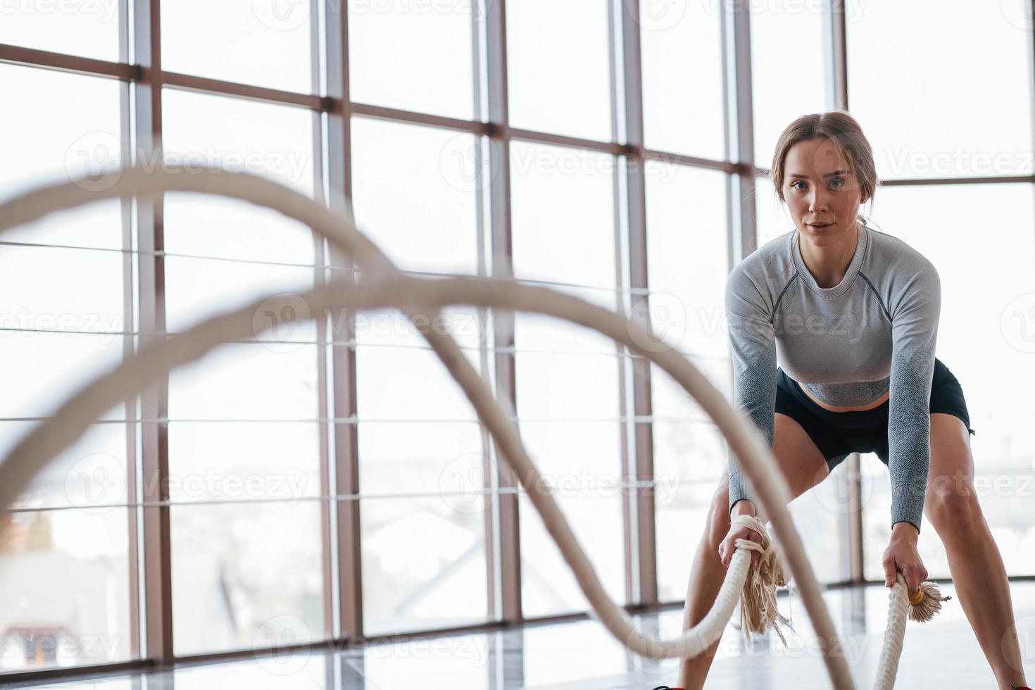 One girl indoors. Sportive young woman have fitness day in the gym at morning time photo