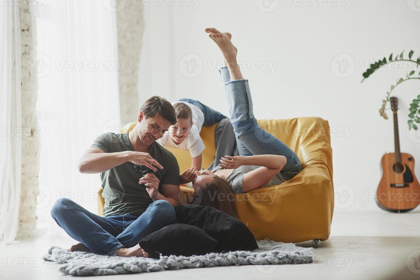 It's photo of your mom. Young couple with kid looking together at the pictures maked by camera